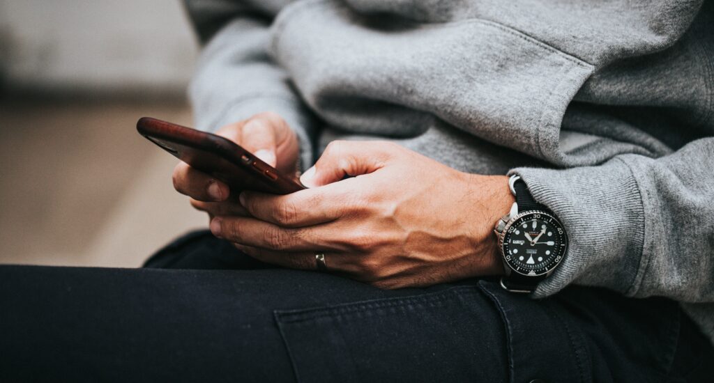 Man wearing a watch on his mobile phone